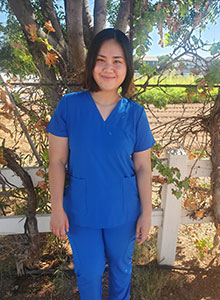 Young Asian woman in blue scrub smiling